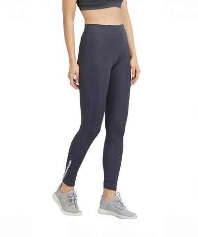 Woman wearing Grey High Waisted Sports Leggings G9 with a black sports bra and gray sneakers stands against a white background.
