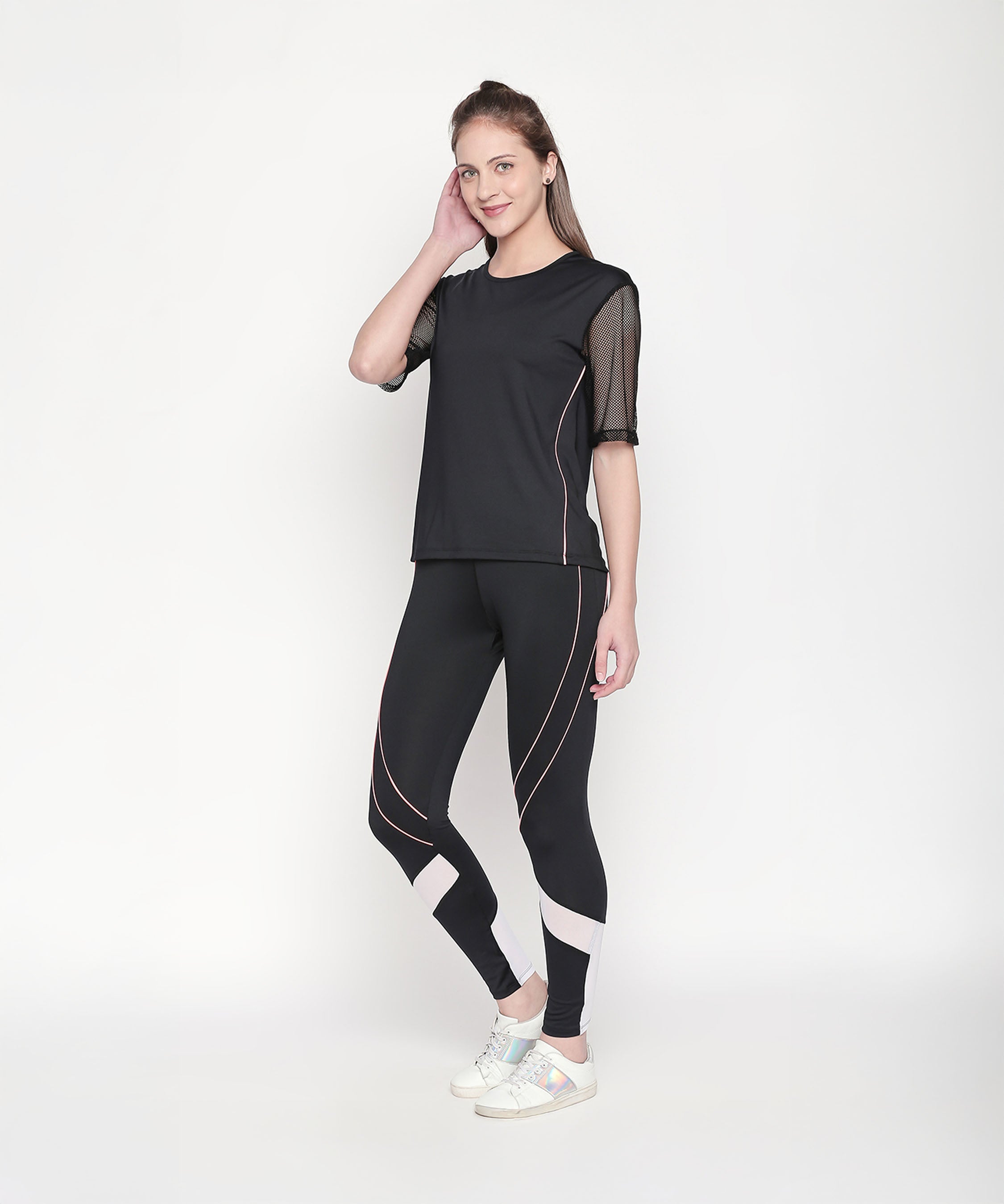 Woman wearing a Black Loose Fit Round Neck Net Half Sleeve Top, featuring moisture-wicking mesh, posing and smiling against a plain white background.