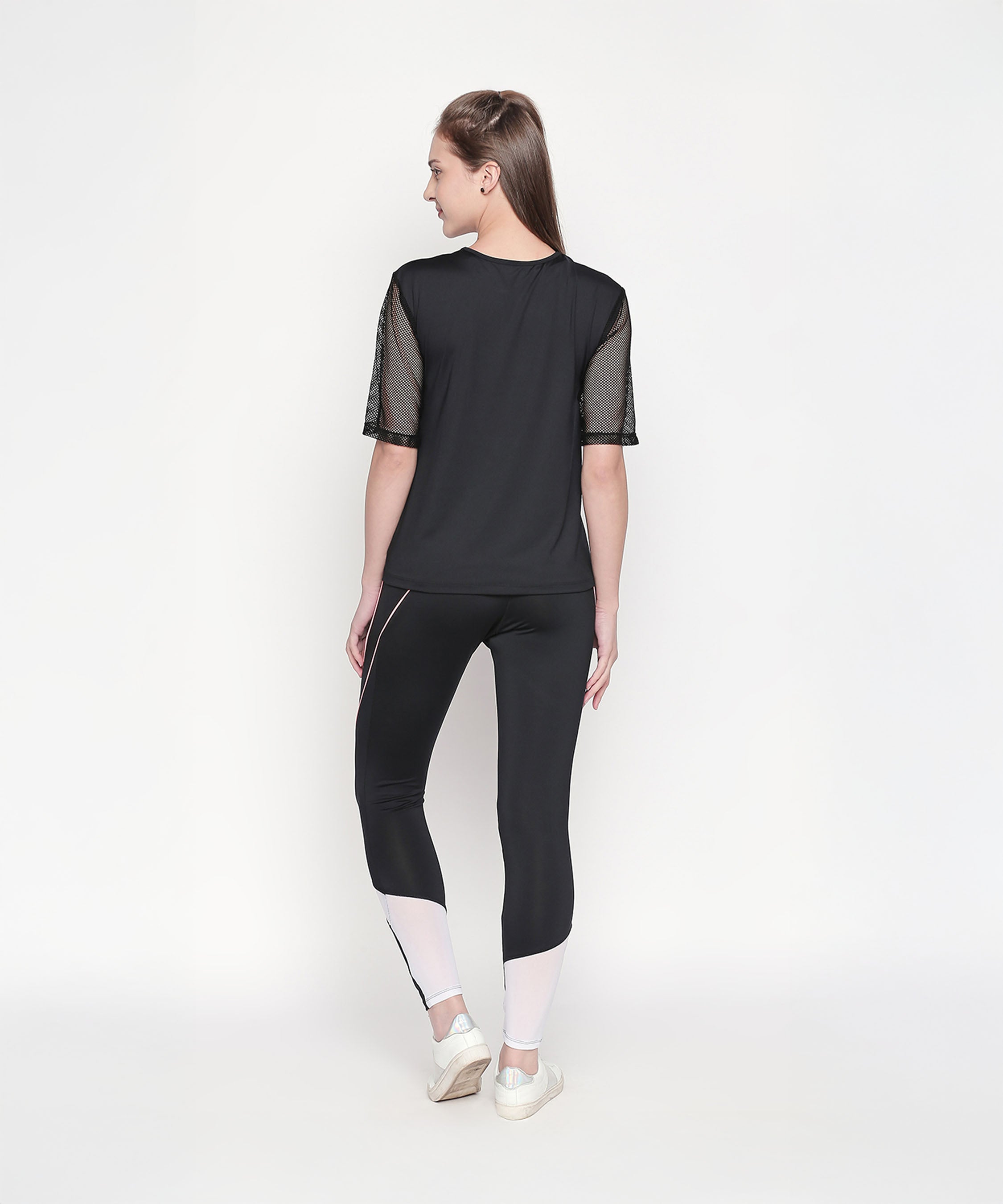 Woman wearing a Black Loose Fit Round Neck Net Half Sleeve Top, moisture-wicking and stylish, facing away on a white background.