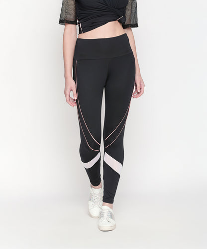 A woman wears the Activewear Black Tracksuit—high-waisted leggings with white and pink accents, paired with white sneakers. The moisture-wicking fabric makes it ideal for workouts.