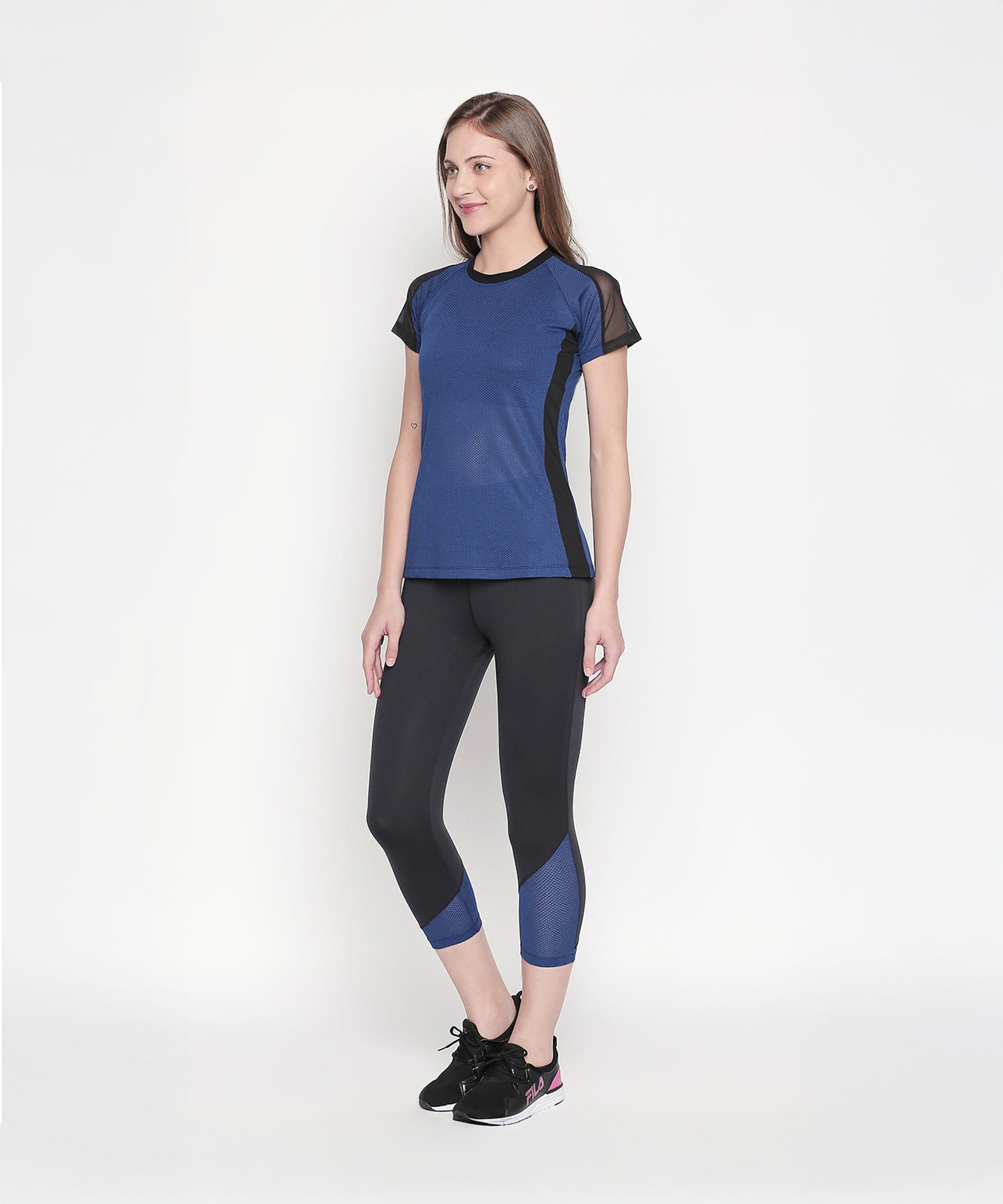 A woman confidently models the Sportswear Dark Blue Tracksuit against a plain white background, showcasing its sleek and sporty design.