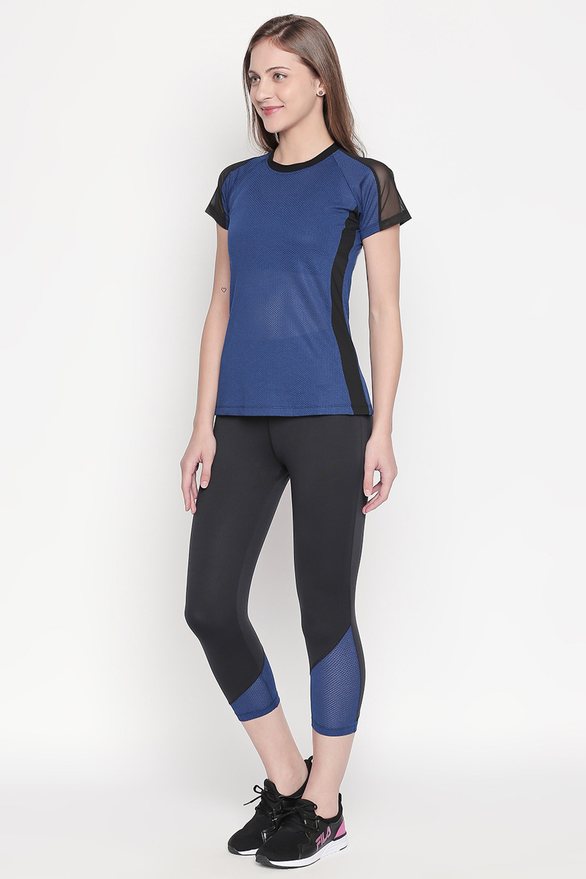 A woman in a Sportswear Dark Blue Tracksuit stands against a plain white background, looking to the side—showcasing her sporty style and workout experience.