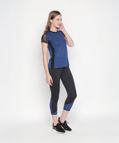 Woman in the Sportswear Dark Blue Tracksuit stands against a white background, looking to the side, ready for her next workout experience.