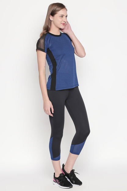 A woman wearing the Sportswear Dark Blue Tracksuit poses with her hand on her cheek and black sneakers, standing against a white background.