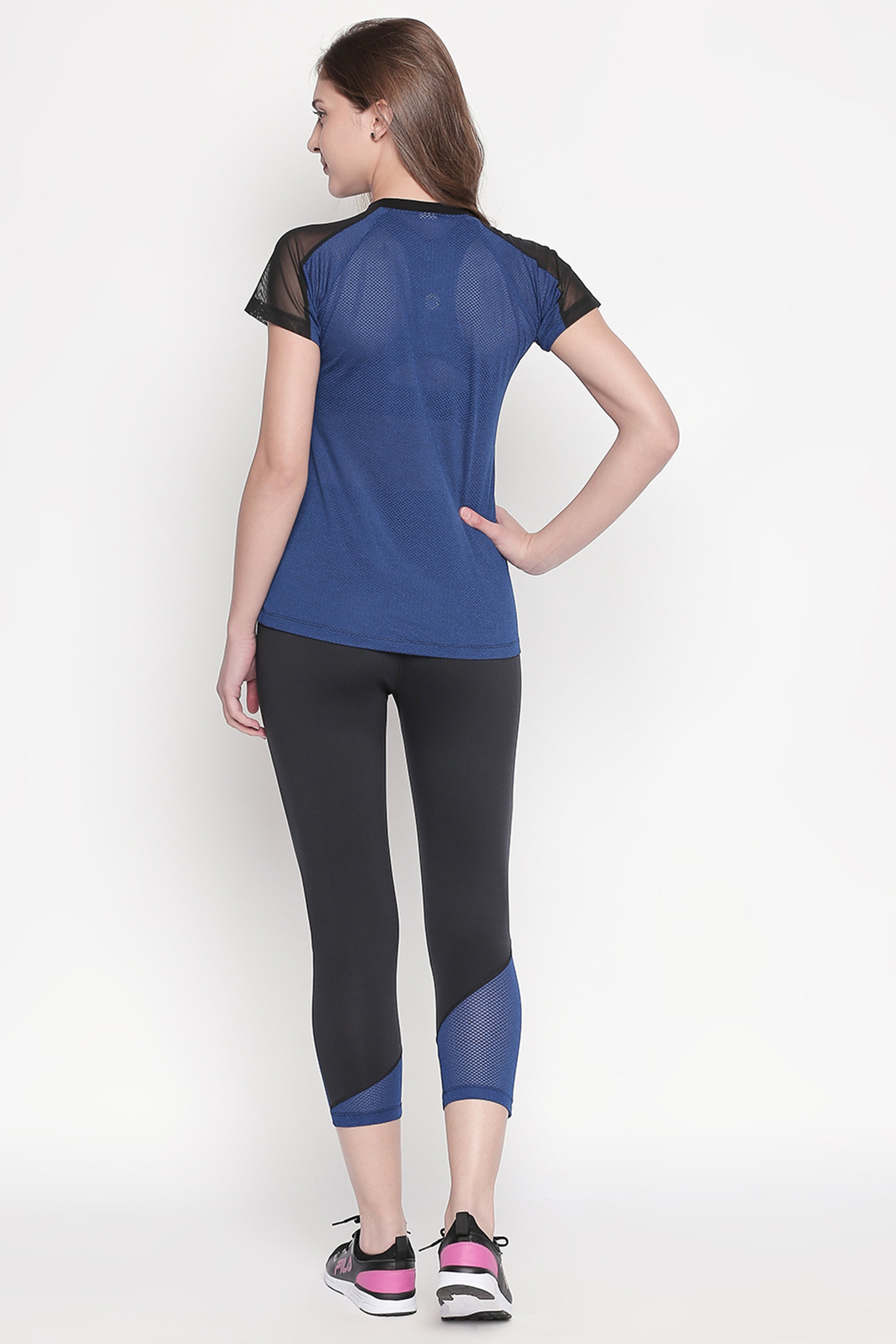 A woman stands with one hand on her hip, modeling the Sportswear Dark Blue Tracksuit, ready to elevate her workout experience against a plain white background.