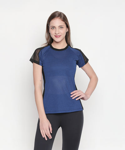 Woman in a Blue - Textured Top With Net Sleeves and black leggings stands against a plain white background, smiling.