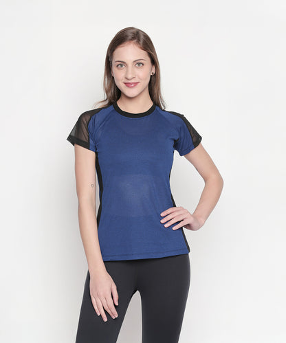 A woman in a Sportswear Dark Blue Tracksuit stands against a plain white background, smiling and radiating post-workout energy.