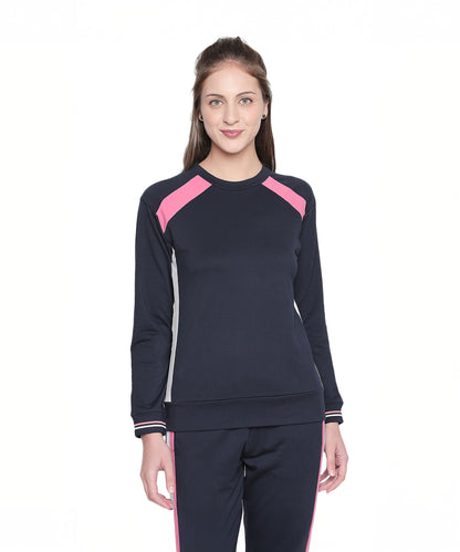 A woman stands smiling in the Sportswear Navy Blue Tracksuit, featuring stylish pink accents—ideal for home workouts or casual outings.