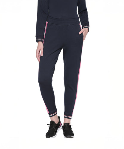 Wearing the Sportswear Navy Blue Tracksuit with pink side stripes and black sneakers—ideal for athleisure style or a cozy workout at home.