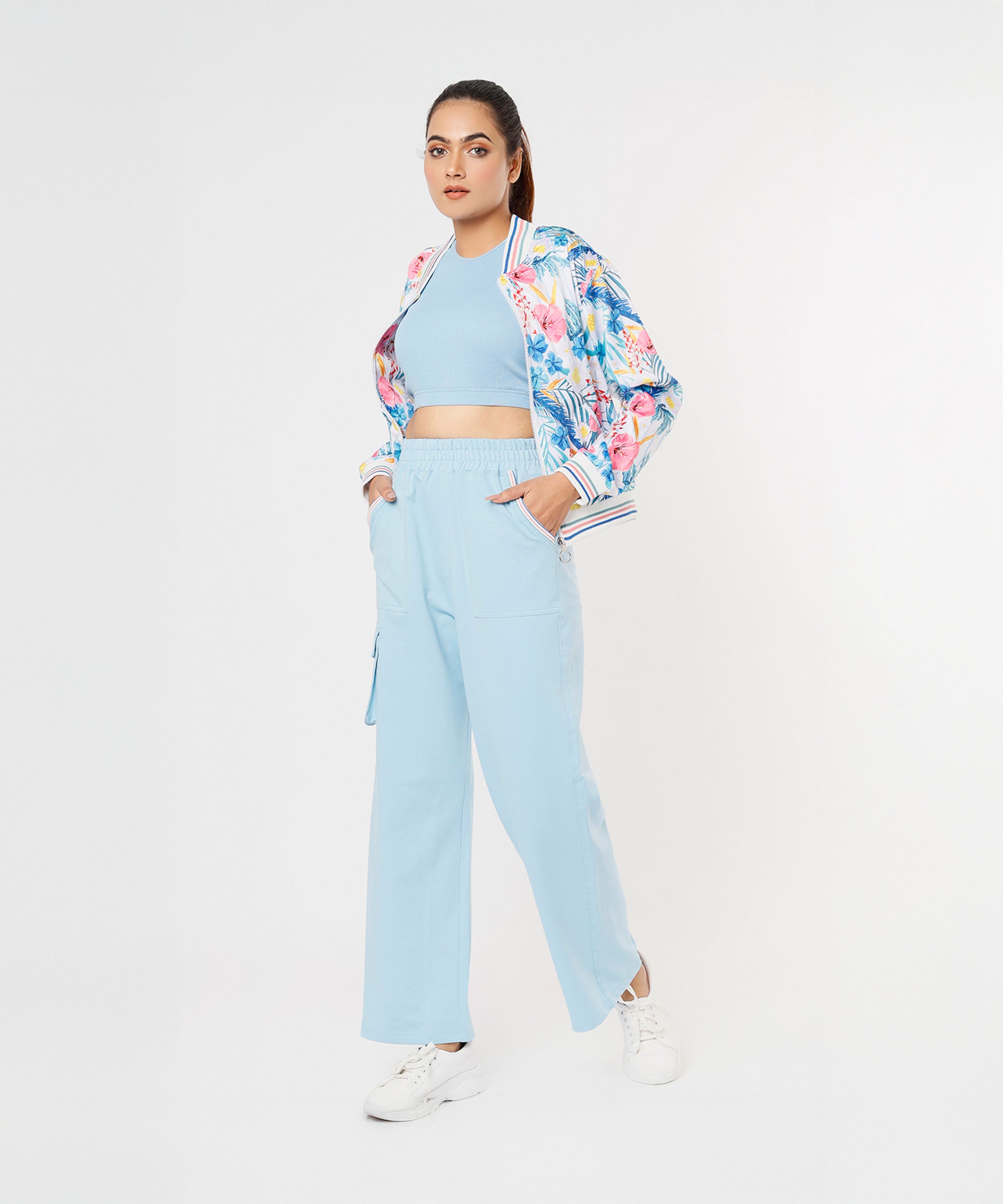 A woman stands with her hands in her pockets, wearing the Blossom Blue Set with Crop Top.