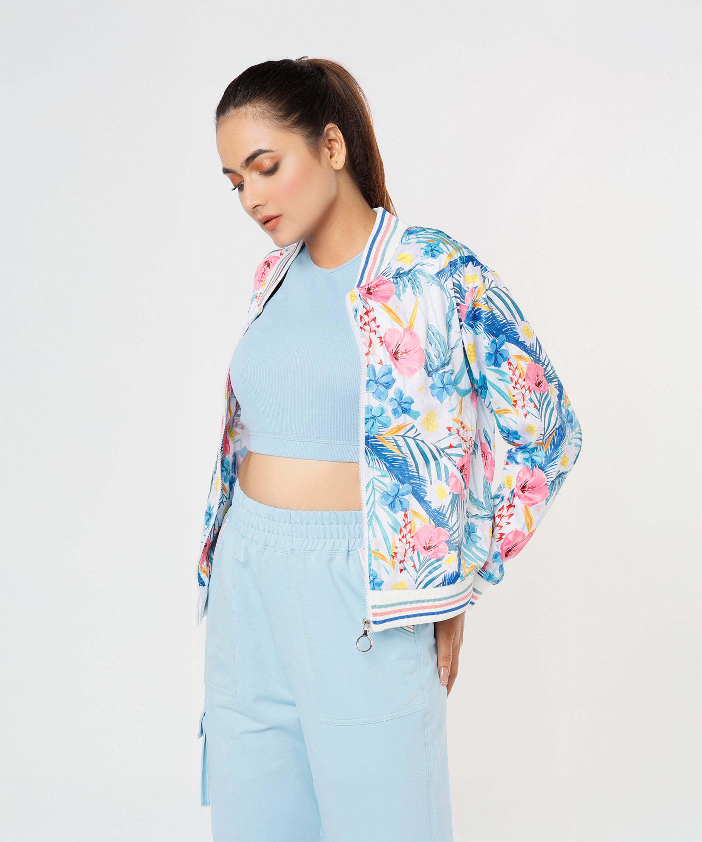 A woman stands against a white background wearing the Blossom Blue Set with Crop Top and cargo track pants.