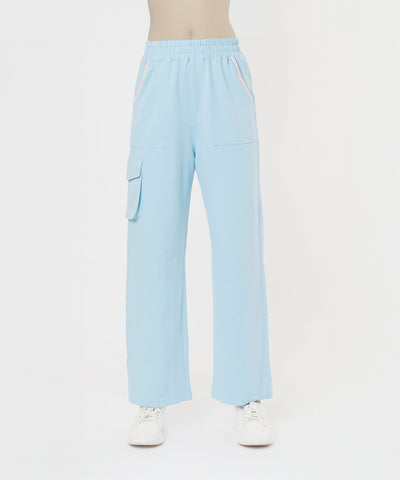 Person wearing the Blossom Blue Set with Crop Top, featuring light blue wide-leg pants with side pockets and white sneakers on a white background.