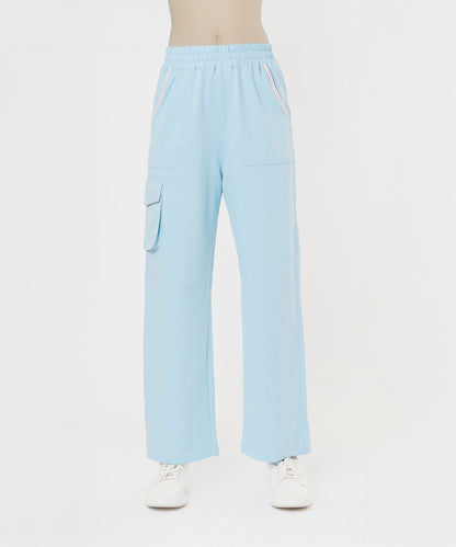 Person wearing the Blossom Blue Set with Crop Top, featuring light blue wide-leg pants with side pockets and white sneakers on a white background.