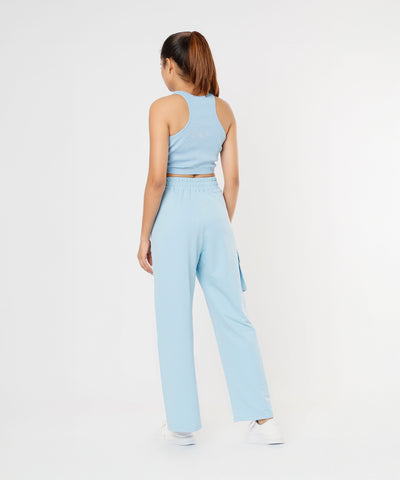 A woman stands with her back to the camera, modeling the Blue Dream Crop Top in powder blue with matching pants.