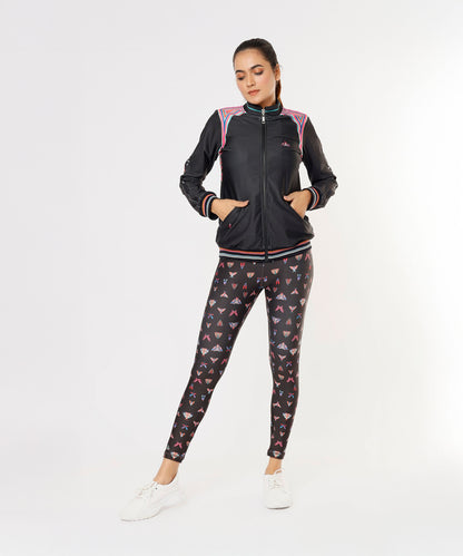 Woman wearing the Tuna Active Black Bomber Jacket and patterned leggings, standing with hands in pockets against a white background.