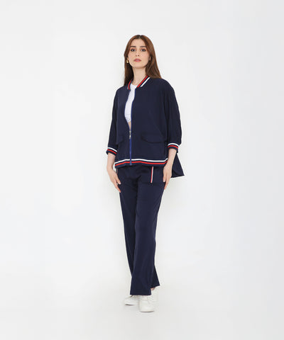 Woman wearing the Navy Blue Zipped Long Jacket with Tracks, featuring red and white stripes—a stylish and sporty women’s activewear set against a plain white background.