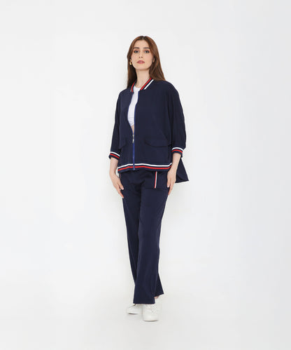 Woman wearing the Navy Blue Zipped Long Jacket with Tracks, featuring red and white stripes—a stylish and sporty women’s activewear set against a plain white background.