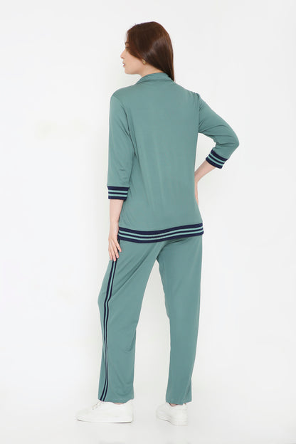 Woman wearing the Sage Green Athleisure Blazer Jacket and Track Set with black stripes, standing and facing away on a white background.