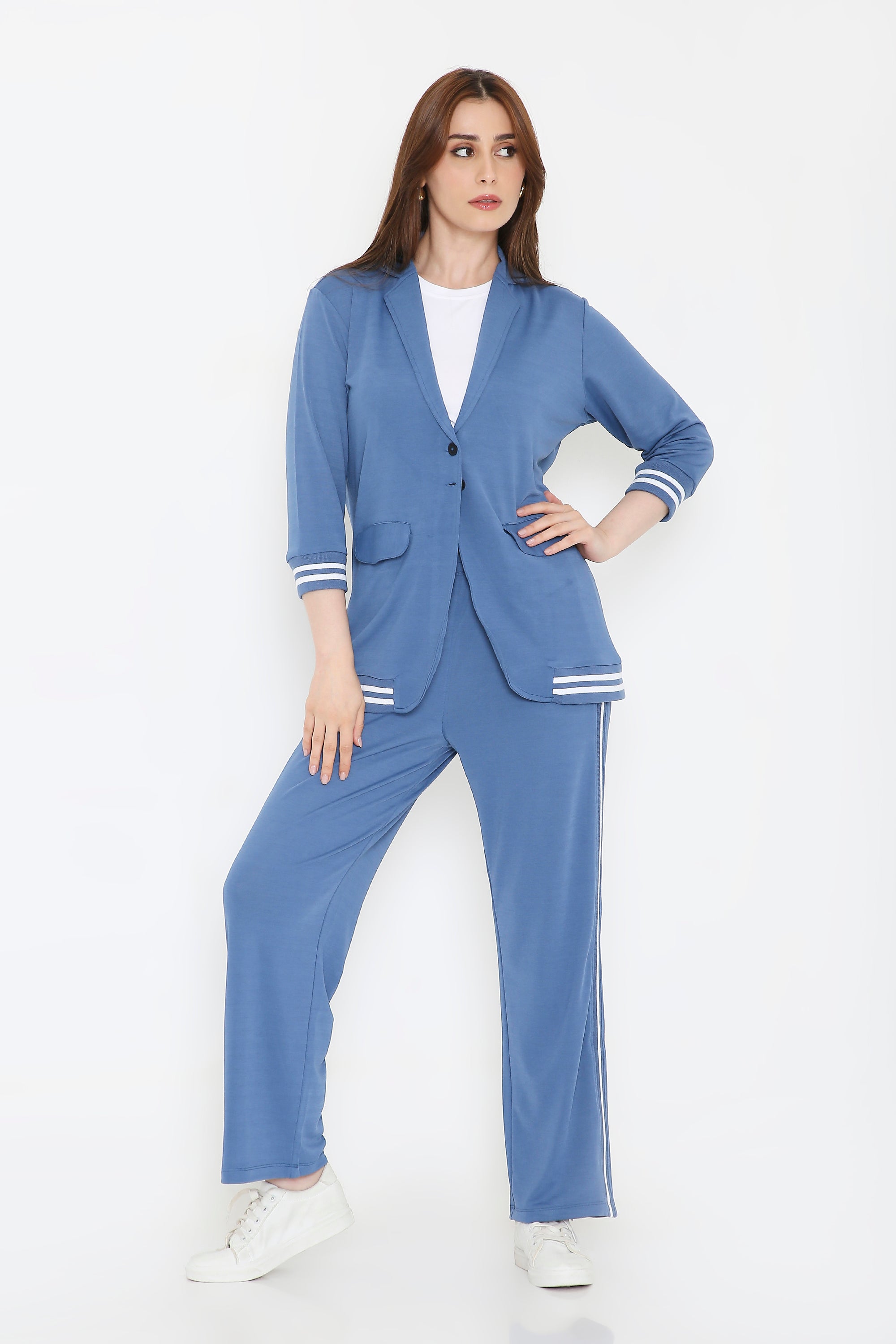 Woman wearing the Atlantic Blue Athleisure Blazer Jacket and Track Set with white stripes, paired with white sneakers, standing against a plain white background.