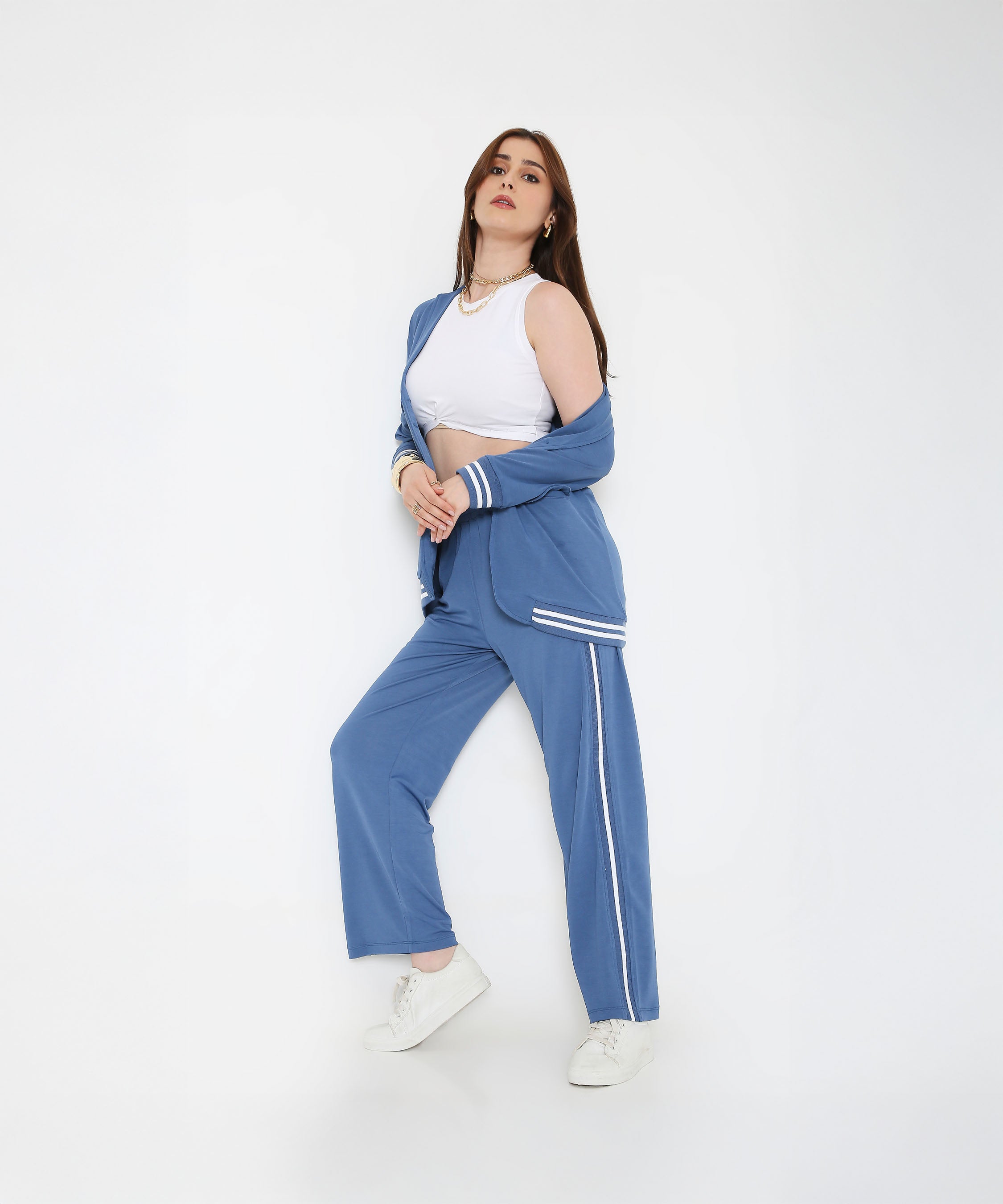 Woman posing in the Atlantic Blue Athleisure Blazer Jacket and Track Set with a white crop top and white sneakers against a plain white background.