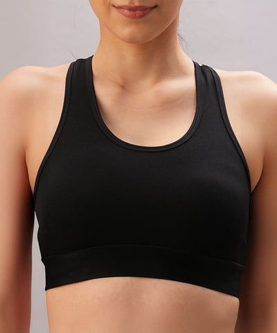 Model wears the Black Sports Bra with adjustable straps, shown from shoulders to waist against a neutral background.