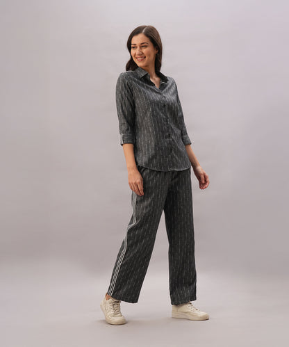 A woman smiles in the Grey Stripes Sleeves Set—coordinated dark striped shirt and matching pants in comfortable fabric—paired with white shoes, standing against a plain background.