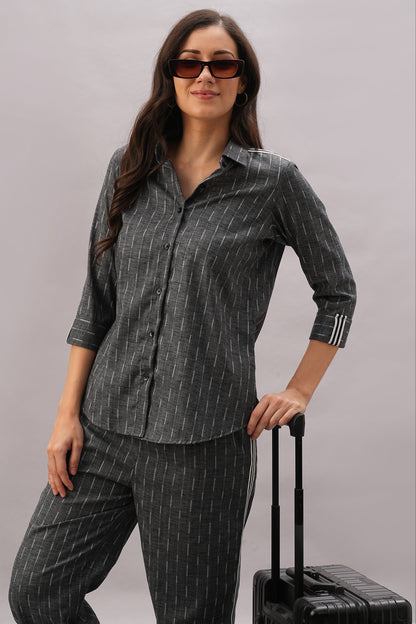 A woman models the Grey Stripes Sleeves Set—featuring a stylish top and comfortable fabric—posing with one hand on a suitcase against a plain background for an effortlessly chic look.