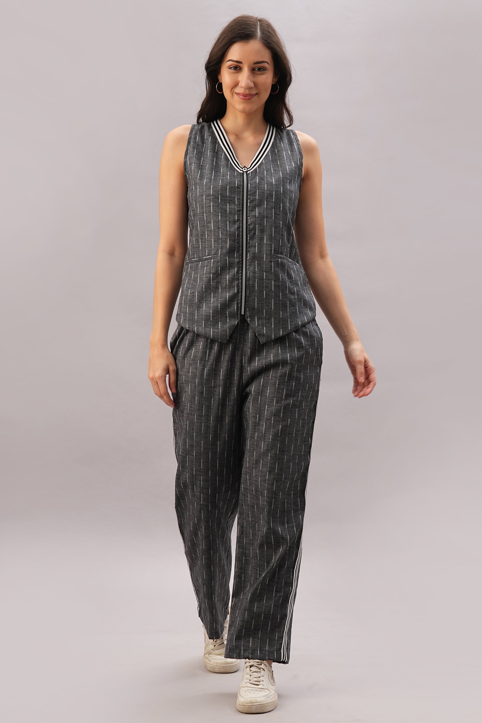 Wearing the Grey Stripes Sleeveless Set styled as a pinstriped co-ord, she completes her confident, modern look with white sneakers.