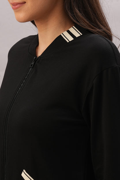 Woman wearing the Black Co-Ord Set—a stylish black zip-up jacket with white stripes—shown from shoulders to chest, perfect for a coordinated look.