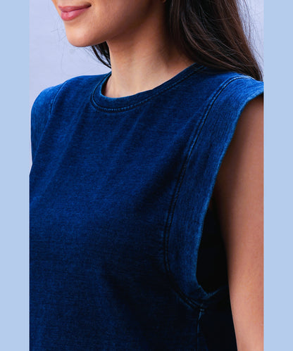 A woman models the Blue Denim Wash Capsleeves Top, showcasing its casual sleeveless style from the shoulders to just above her lips.