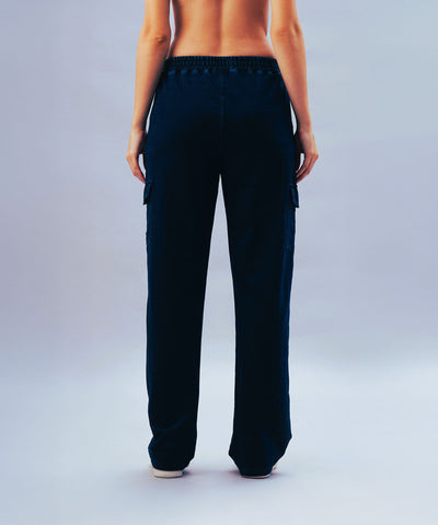 A person stands barefoot, shown from the back against a light background, wearing Blue Denim Wash Cargo Trackpant.