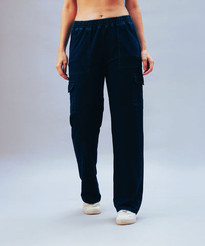 Person wearing black cargo pants and white sneakers, standing against a light background—showcasing effortless style similar to Blue Denim Wash Cargo Trackpant with its classic denim-inspired wash.