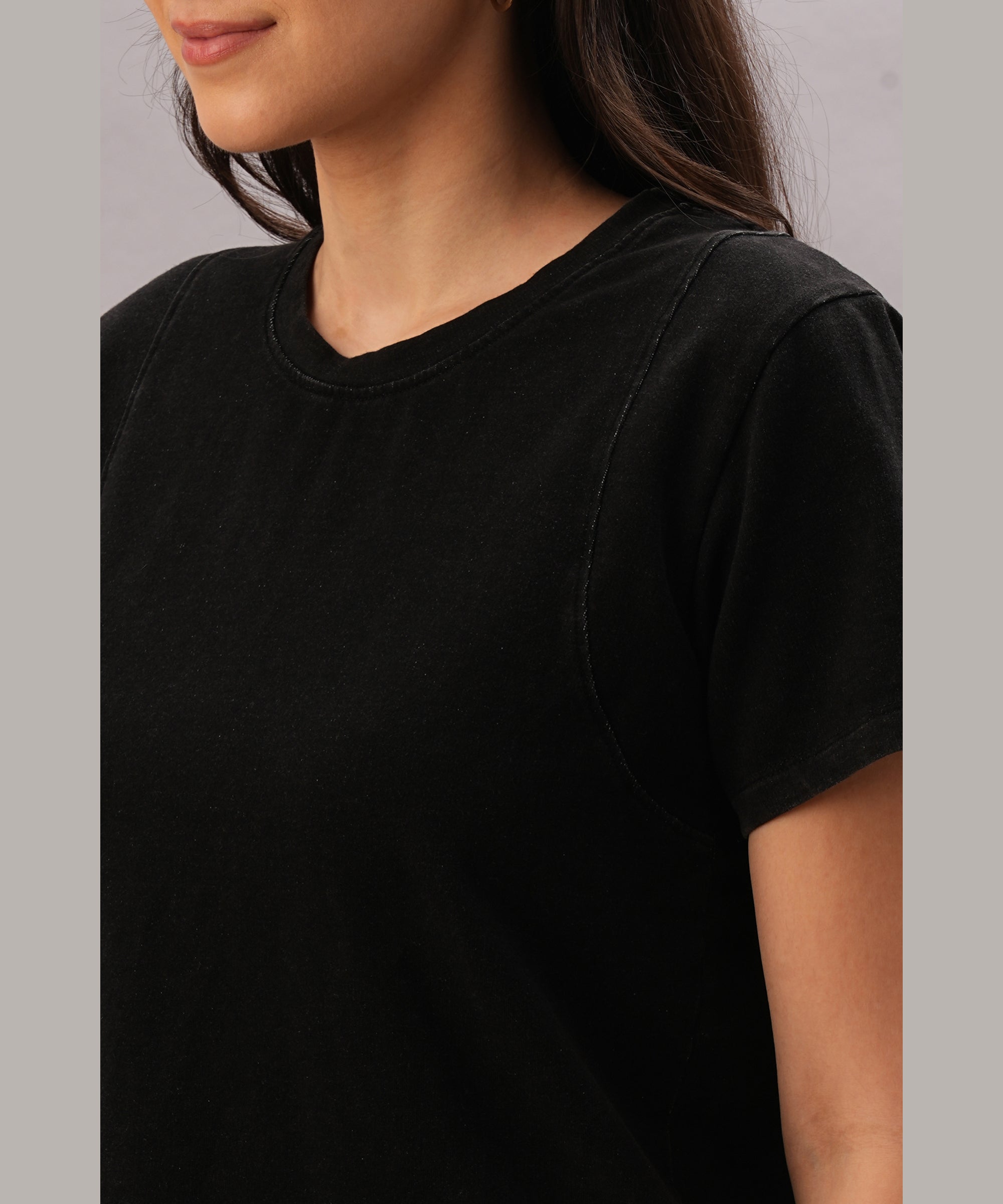 Woman wearing the Black Denim Wash Workout Tee, a plain short-sleeve moisture-wicking t-shirt in black, shown from shoulders to mid-torso, facing sideways.