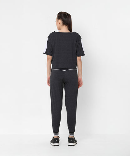 Woman wearing the Melange Dark Grey Set joggers and a comfort fit top, standing with her back to the camera against a white background.