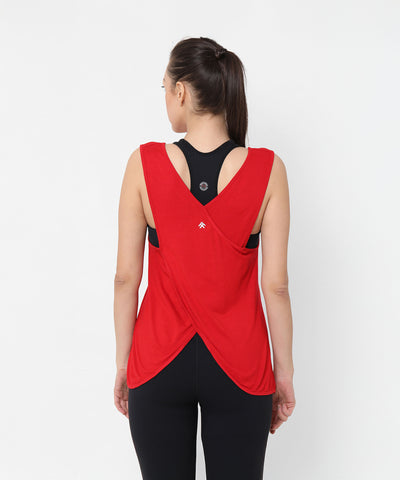 Woman wearing black leggings and sports bra, topped with a Red Tank Top With Overlap Back, facing away.