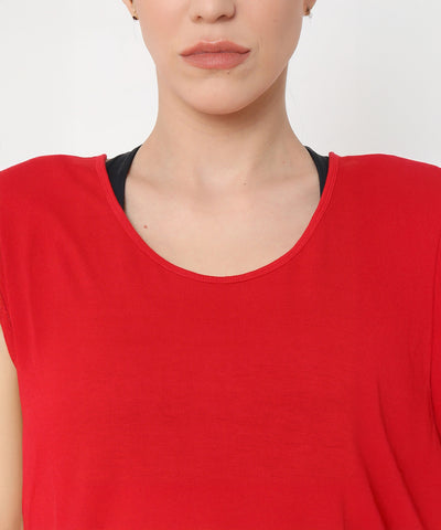 A woman wearing the Red Tank Top With Overlap Back and a black undershirt, shown from shoulders to lips against a white background.