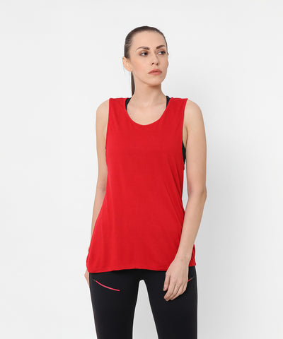 Woman wearing a Red Tank Top With Overlap Back and black pants stands against a plain white background, looking to the side.