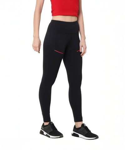 A woman stands on a white background wearing Black Leggings With Zip, a red crop top, and black sneakers.