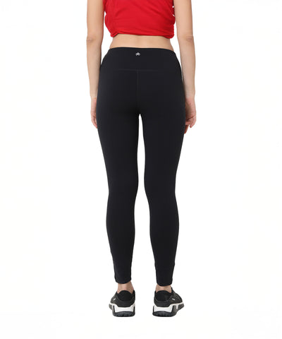 A person shown from the back wears a red crop top, Black Leggings With Zip (high-waisted with zippered pockets), and black sneakers.
