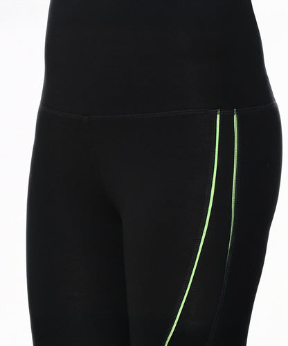 Model showcases Fab Fit Neon Pop Leggings in black with neon green side stripes and a high-rise waistband, visible from waist to mid-thigh against a white background.