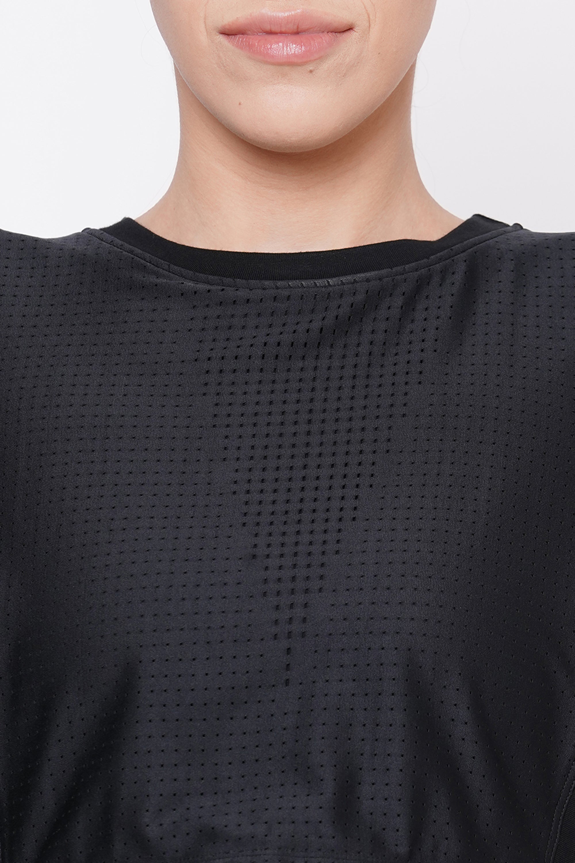 A person models the Black Crop Top With Mesh Overlay, revealing only the lower face and neck.