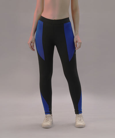 A person models the Black and Blue Pants, crafted from four-way stretch fabric, paired with white sneakers against a plain gray background.