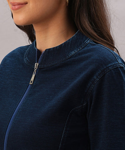 A woman is shown from the shoulders up wearing the Blue Denim Wash Jacket, featuring a dark blue wash and a high collar.