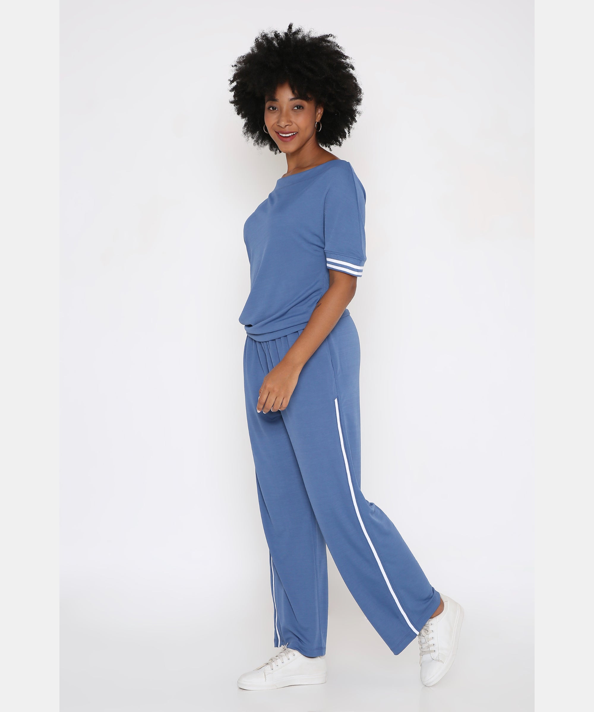 Sporty Atlantic Blue Off-Shoulder Tracksuit Set—features white stripes, paired with white sneakers for relaxed, confident athleisure style against a clean white background.