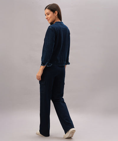 Woman wearing a Blue Denim Wash Jacket over a navy loungewear set stands facing away, looking back over her shoulder against a plain background.