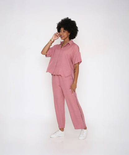 Woman wearing the Vintage Pink Loose Shirt and Pant Cord Set with white sneakers, smiling and posing against a plain white background.