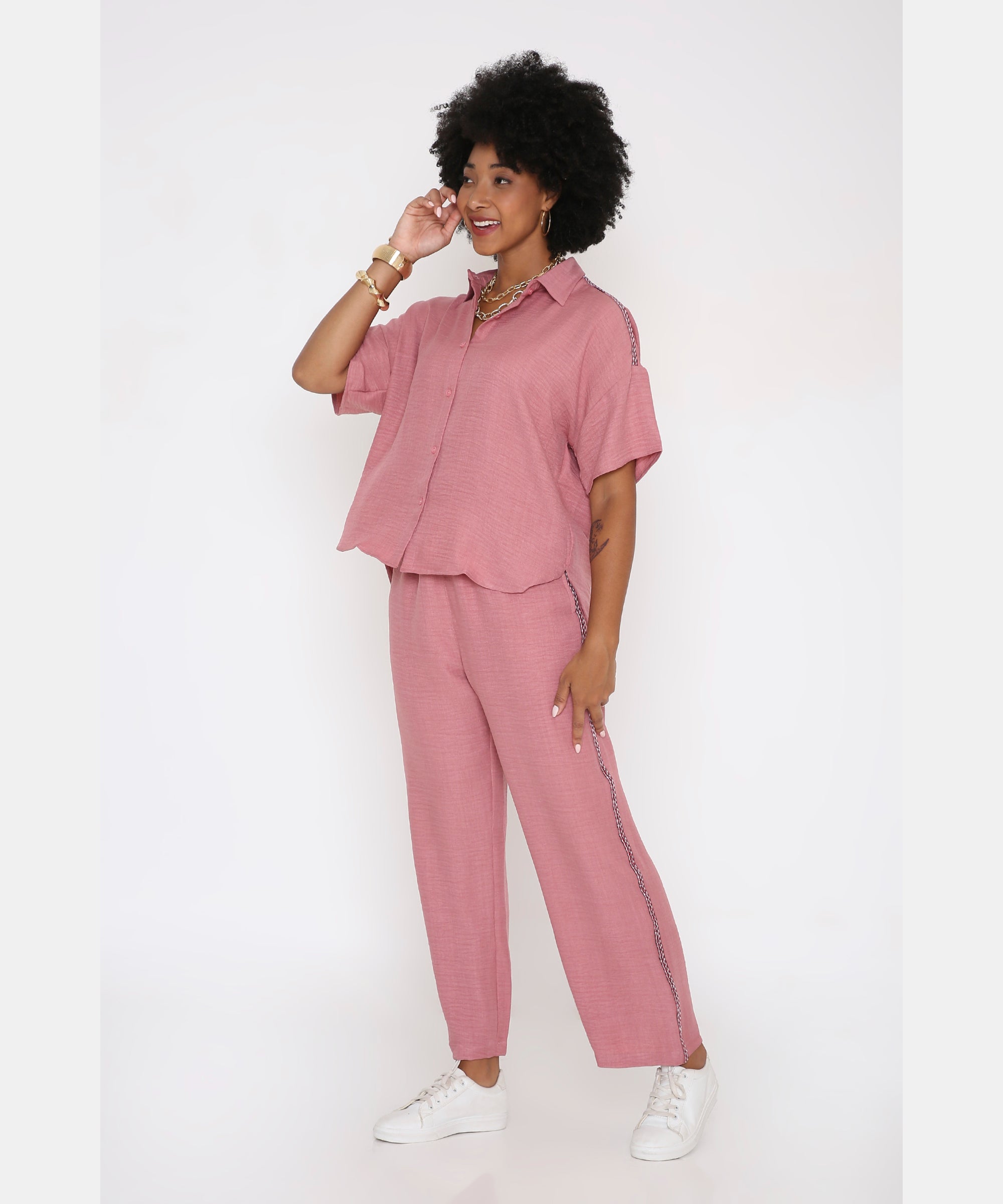 Woman in a Vintage Pink Loose Shirt and Pant Cord Set with wide-leg pants and white sneakers, standing and smiling.
