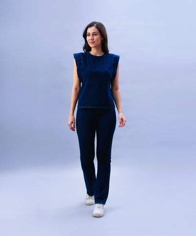 A woman wearing a Blue Denim Wash Capsleeves Top and matching pants walks against a light blue background.