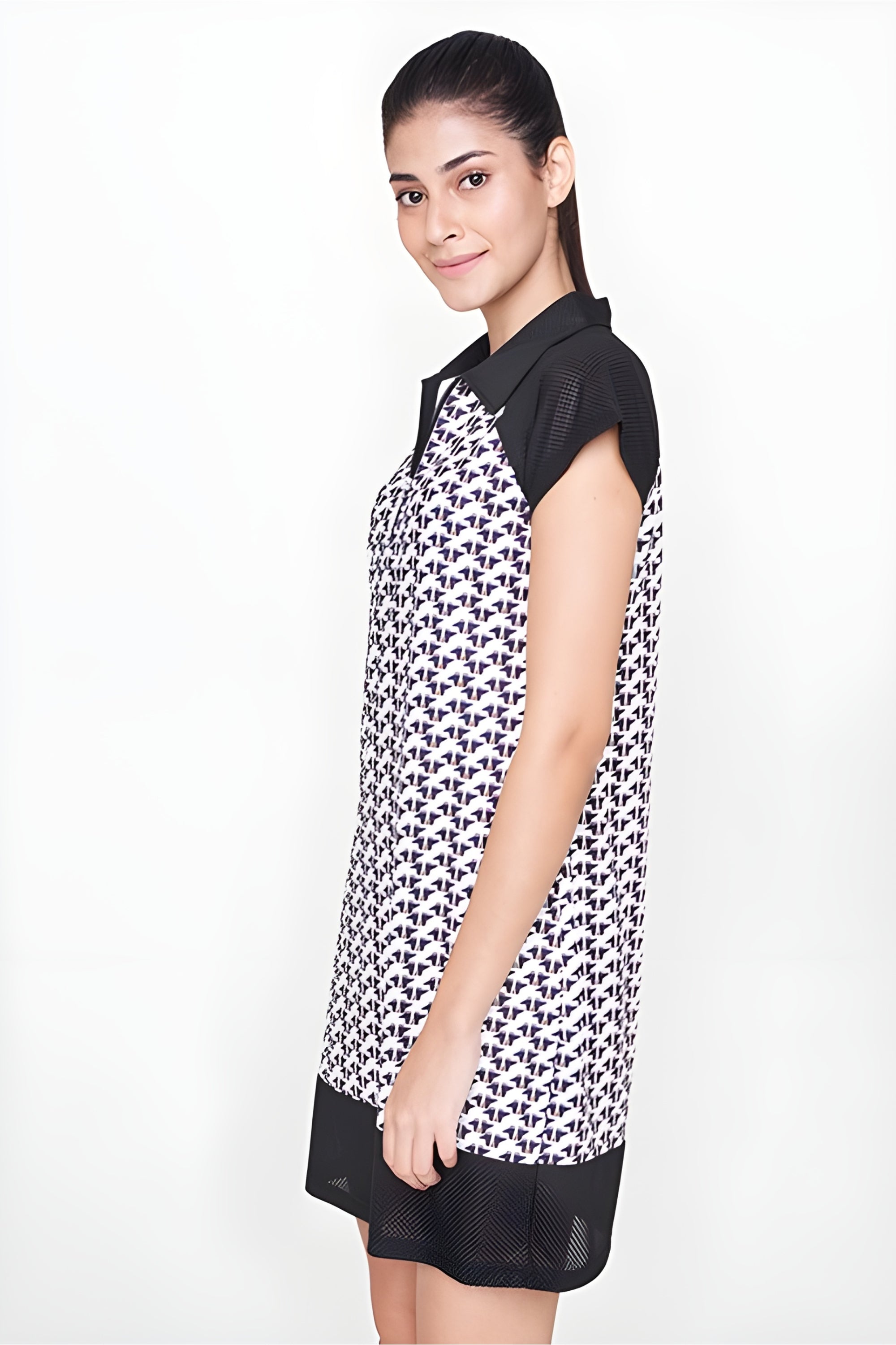 Woman in a chic Black Dress made of polyester with a geometric black and white pattern, standing sideways and smiling—perfect for an airport look.