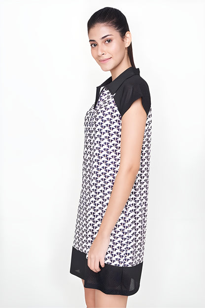 Woman in a chic Black Dress made of polyester with a geometric black and white pattern, standing sideways and smiling—perfect for an airport look.